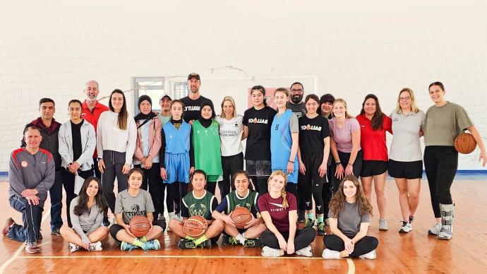 澳门金沙线上赌博官网 delegation to Uzbekistan and Uzbek students pose for a photo on a basketball court