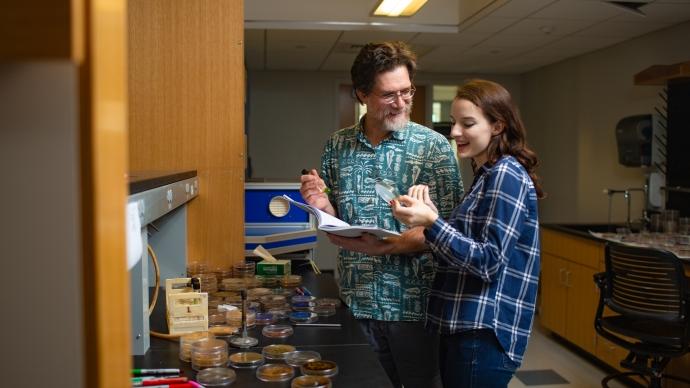 frank healy and kate warford examine a lab sample inside a laboratory