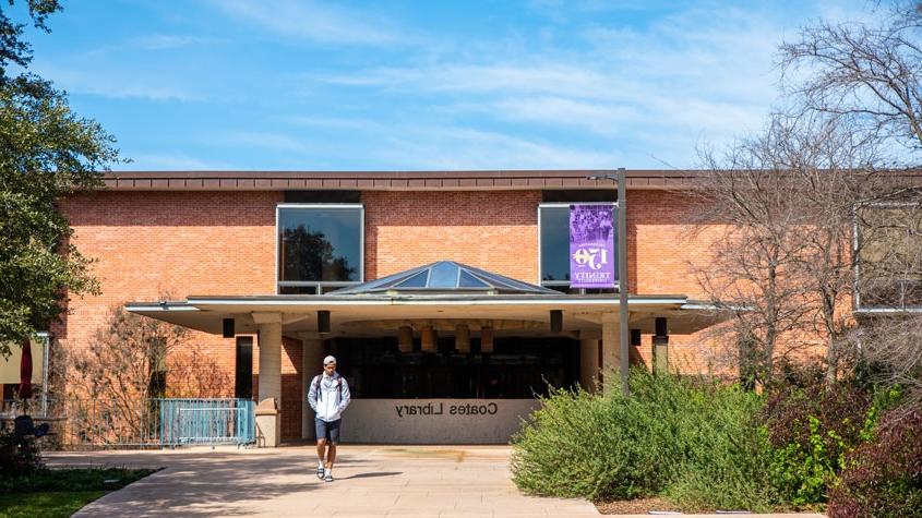 student walking in front of coates library