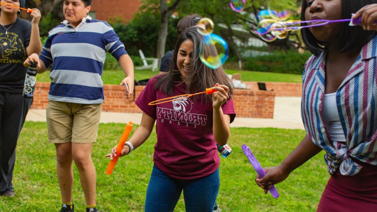 Carolina Molina plays with a large bubble wand with friends